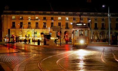 Tranvía amarillo tradicional circulando por Lisboa de noche en el centro histórico de Portugal, símbolo del turismo y la identidad urbana.